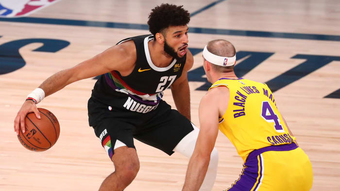 Nuggets guard Jamal Murray dribbles the ball around Los Angeles Lakers guard Alex Caruso